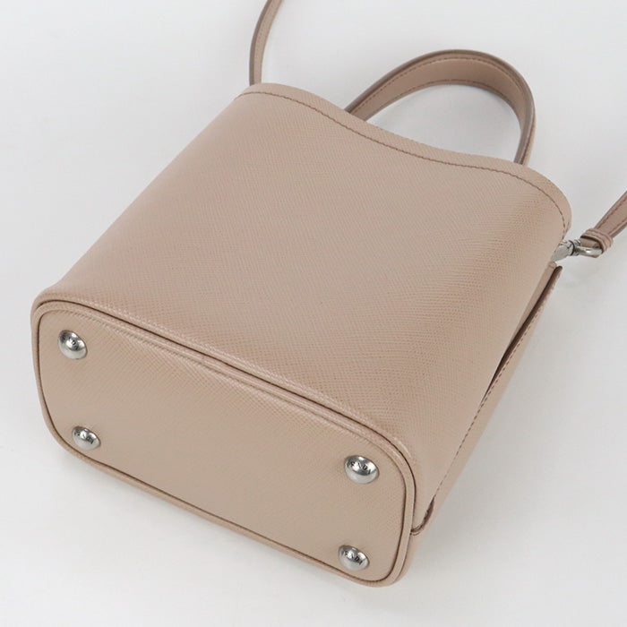 Beige handbag with silver studs on a white background