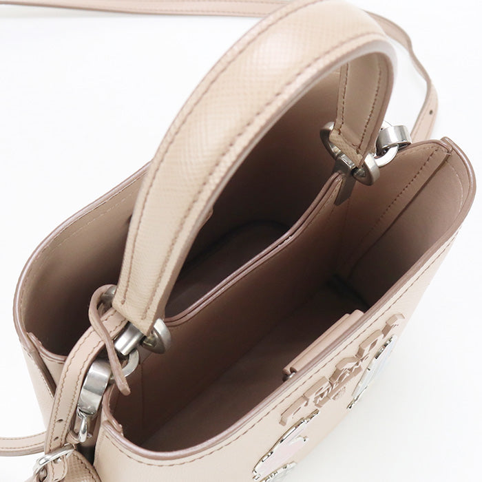 Close-up of a beige handbag with a strap on a white background