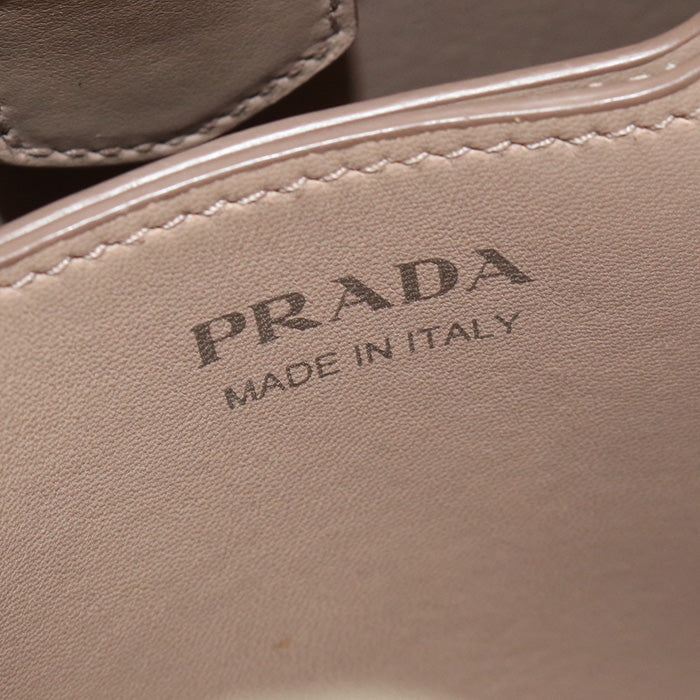 Close-up of a Prada handbag with 'Made in Italy' text on beige leather.