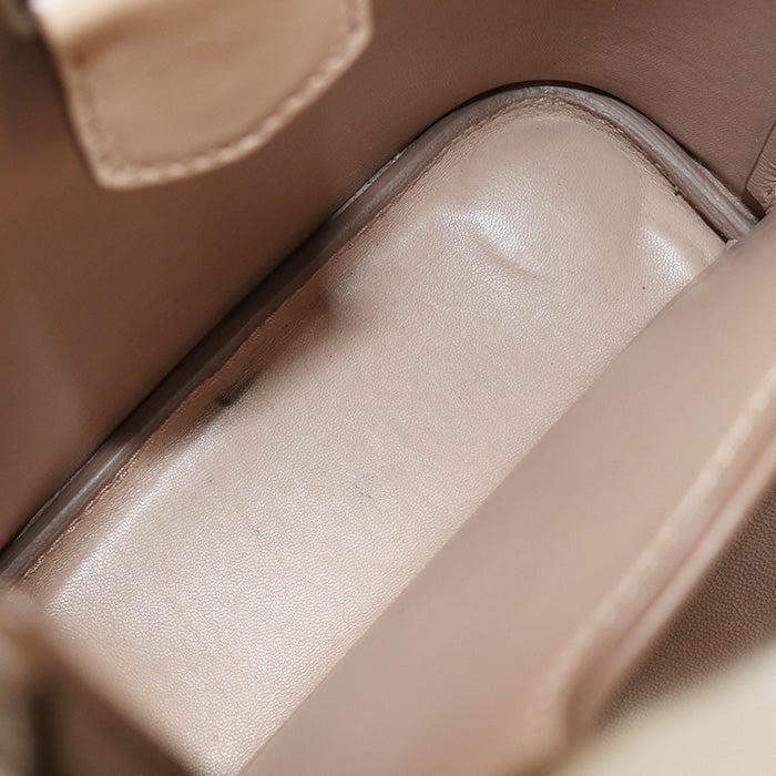 Close-up of a beige leather handbag with a focus on the interior.