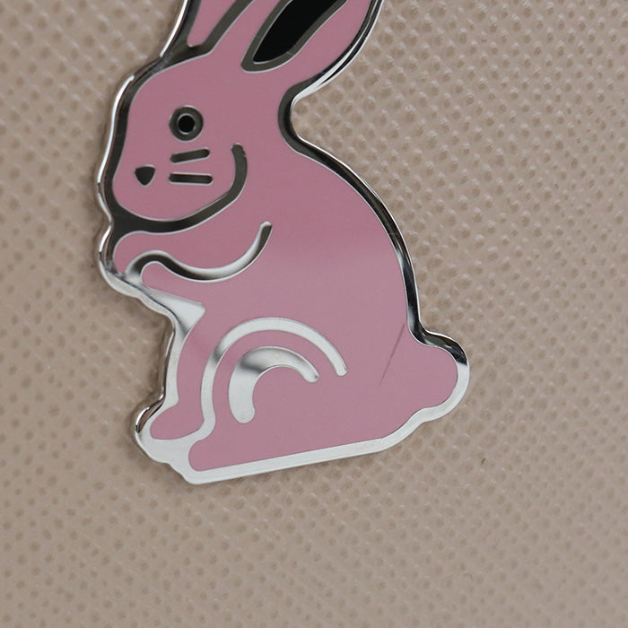 Pink bunny-shaped object on a beige background
