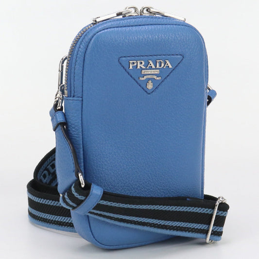 Blue Prada handbag with a strap on a white background
