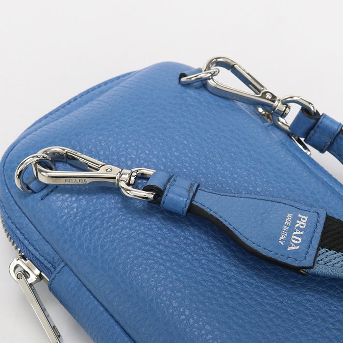 Blue Prada handbag with a strap on a light gray background